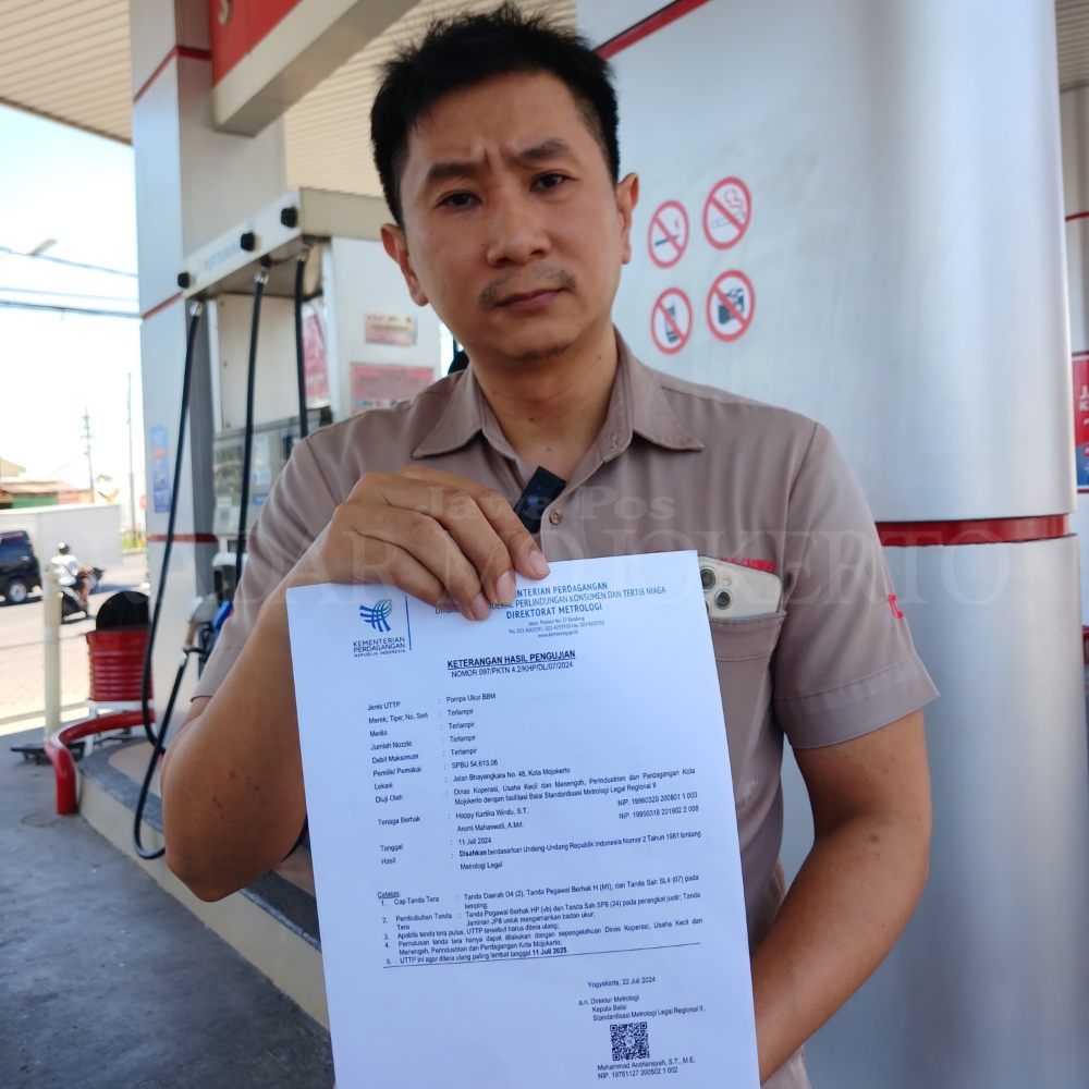 PATUH : Hani, pengurus SPBU Bhayangkara Kota Mojokerto menunjukkan sertifikat lulus tera tahunan yang dikeluarkan Kementerian Perdagangan, Rabu (4/9/2024).