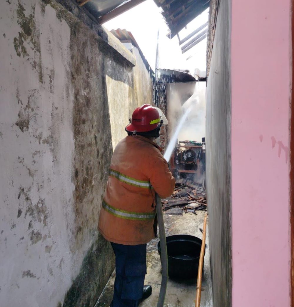 PEMADAMAN: Petugas Damkar BPBD Kabupaten Mojokerto memadamkan api yang membakar rumah warga di Desa Pacing, Kecamatan Bangsal, Mojokerto, Kamis (5/9).