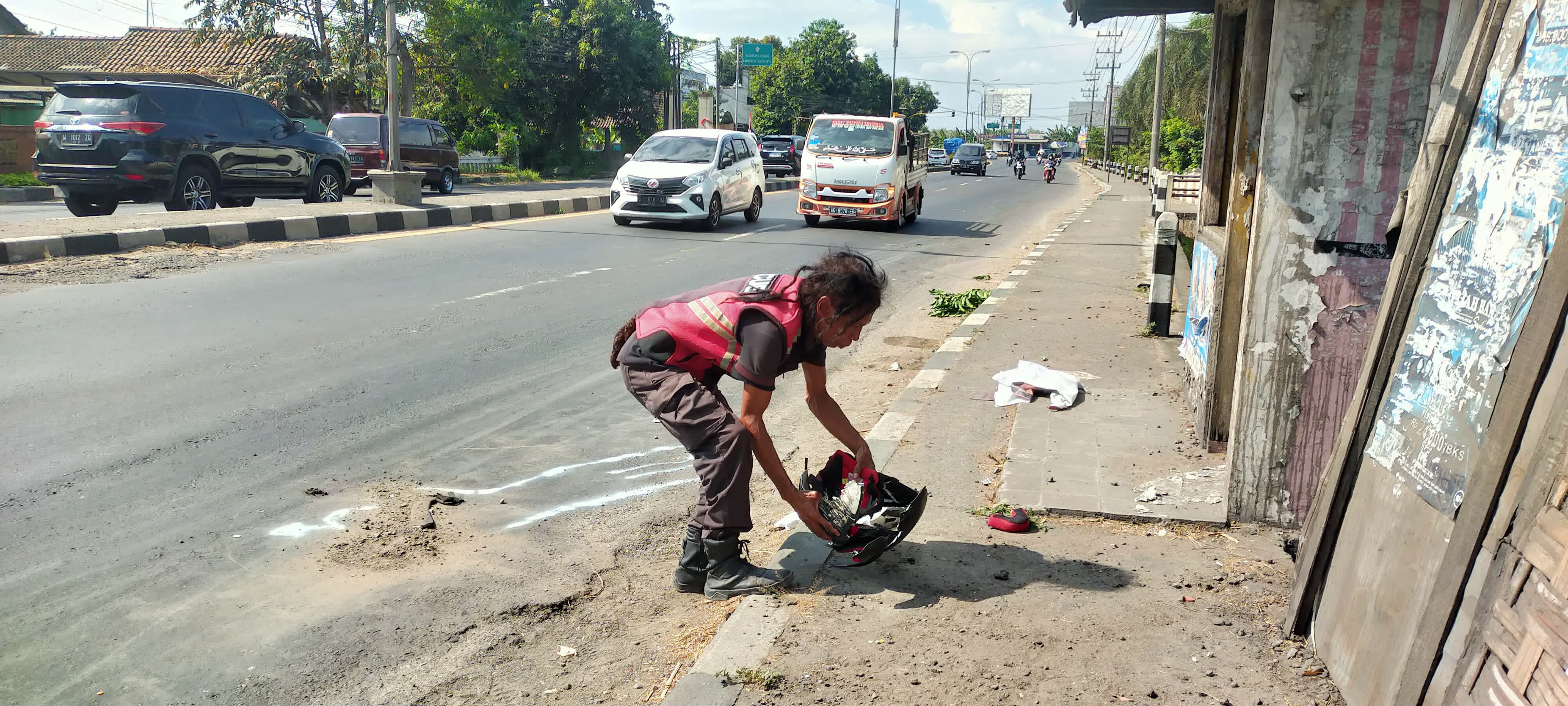 NAHAS: Relawan menunjukkan helm korban yang pecah di lokasi, Minggu (8/9).