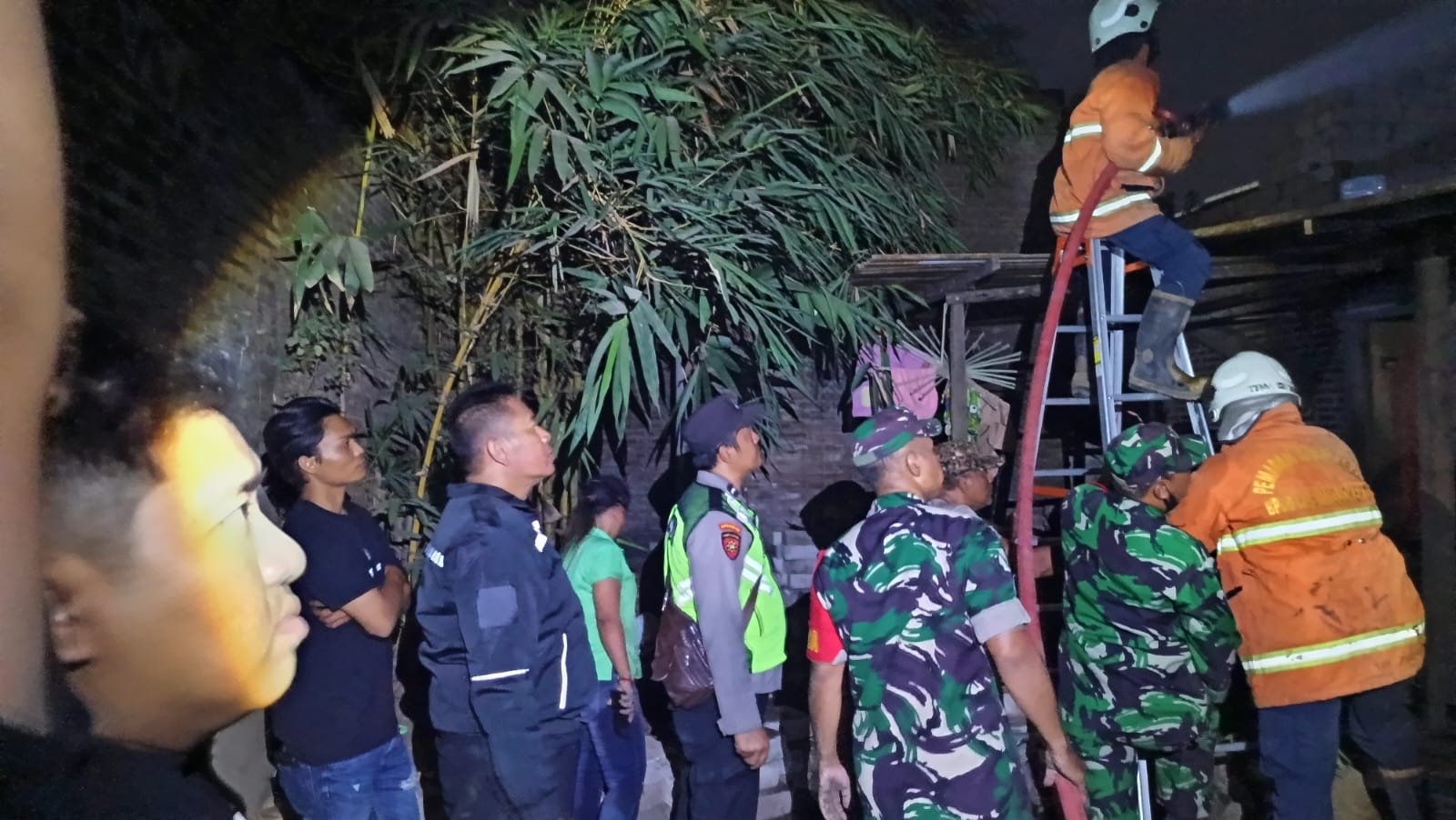 AGAR PADAM: Petugas gabungan berjibaku memadamkan api yang melalap rumah sekaligus toko servis elektronik di Desa Wonosari, Kecamatan Ngoro, Selasa (17/9) malam.