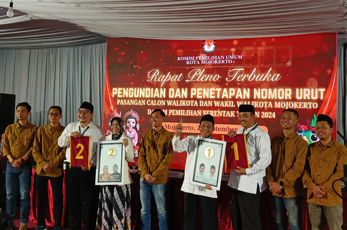 KONTESTAN: Dua paslon menunjukkan nomor urut hasil pengundian dalam rapat pleno terbuka di kantor KPU Kota Mojokerto, Senin (23/9) malam.