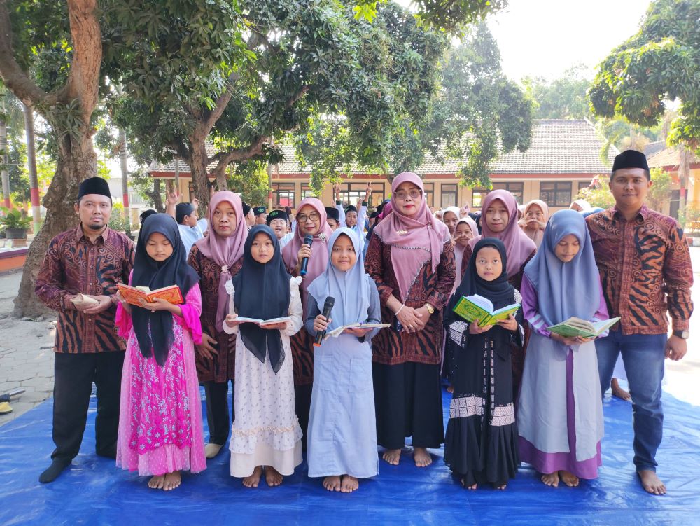 TUNTAS: Kepala SDN Tampungrejo Ponitri Sulistiowati dan seluruh murid usai pelaksanaan khatam Alquran dalam peringatan Maulid Nabi, Sabtu (21/9).