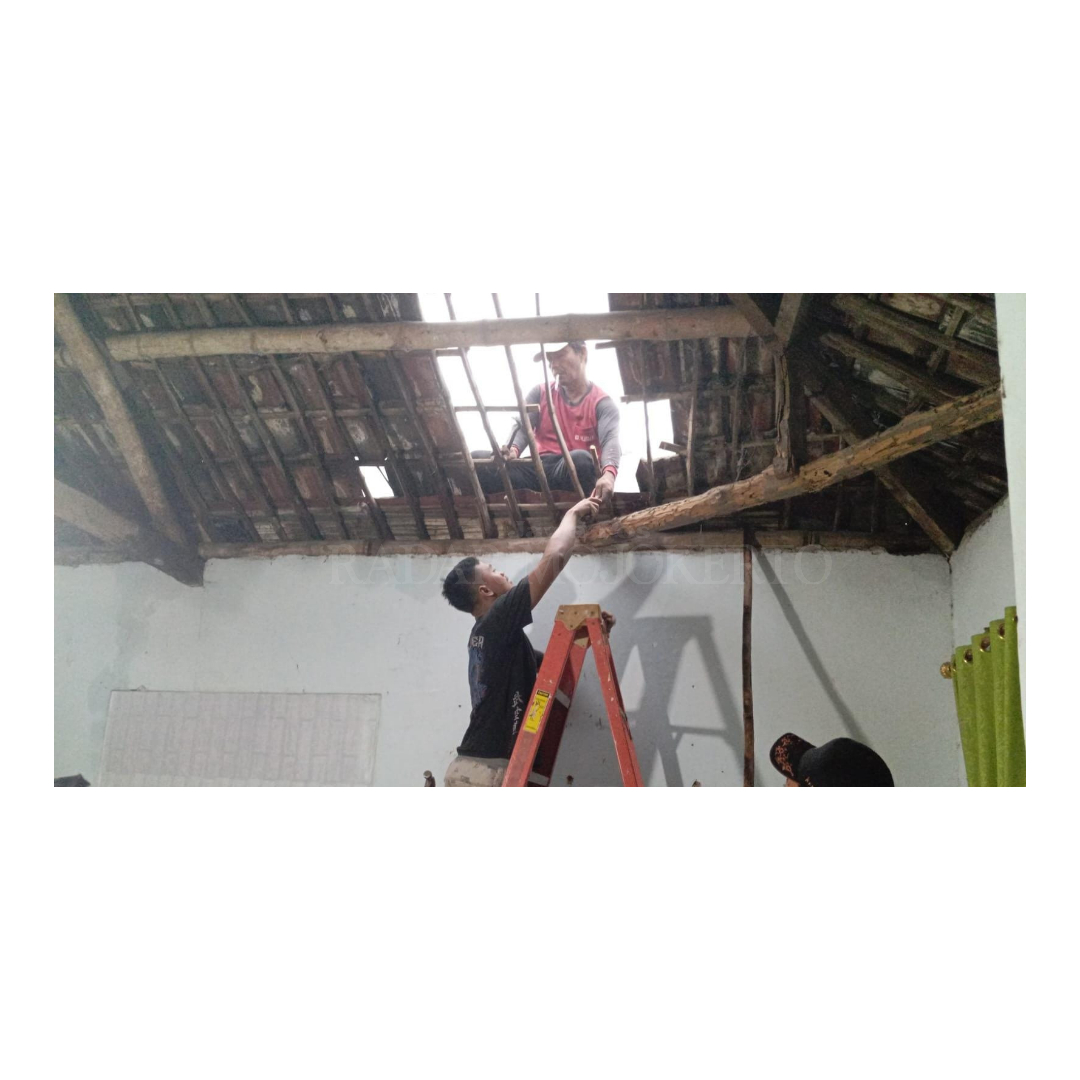 MELOMPONG: Warga Desa Sampangagung, Kecamatan Kutorejo, Mojokerto, berjibaku memasang genting rumah yang tersapu angin kencang, Rabu (25/9).