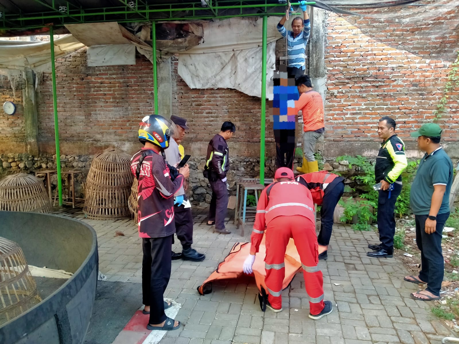 DIDUGA DEPRESI: Relawan PMI Kota Mojokerto bersama petugas Polsek Prajurit Kulon mengevakuasi jasad korban gantung diri di pekarangan belakang Pasar Prajurit Kulon, kemarin (28/9).
