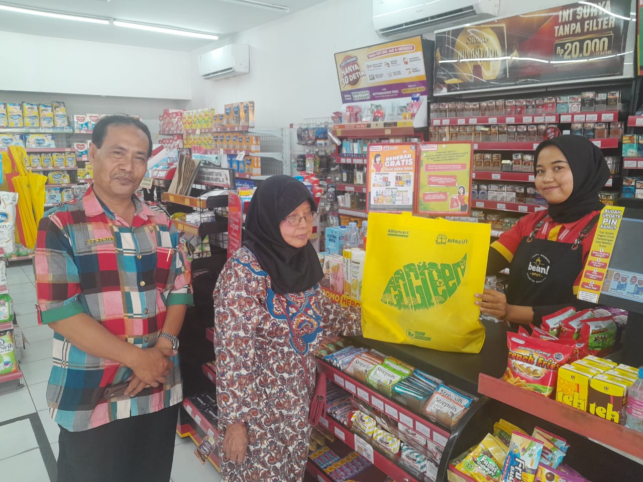 PEDULI: Salah satu karyawan Alfamart Gemekan Kecamatan Sooko, Kabupaten Mojokerto membagikan Tas Go Green gratis ke konsumen.