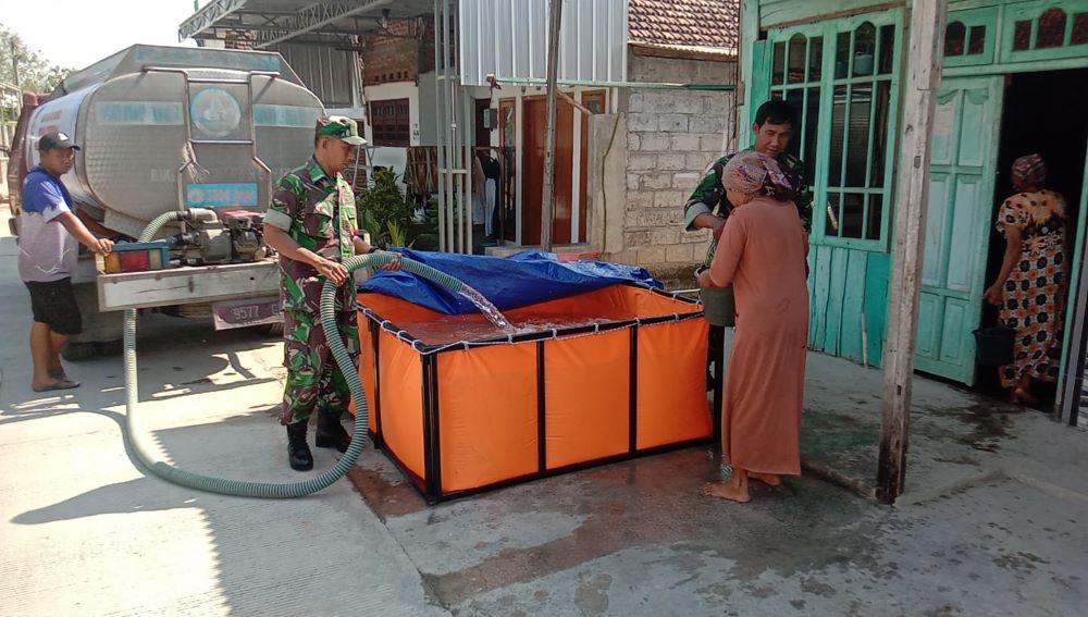 PEDULI: Penyaluran air bersih oleh personel TNI di Dusun Tempuran, Desa Simongagrok, Kecamatan Dawarblandong, kemarin (2/10).