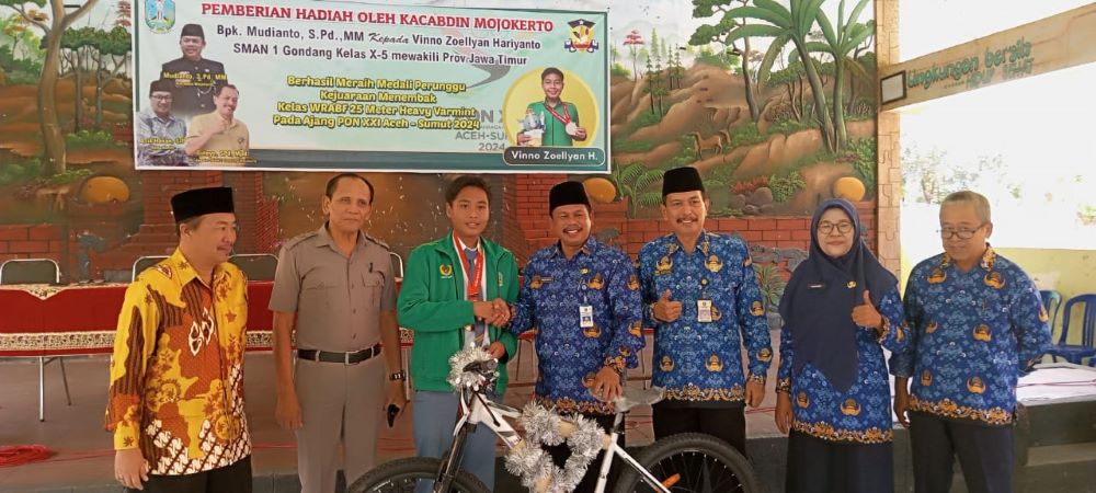 DIAPRESIASI: Kacabdindik Jatim Wilayah Kabupaten dan Kota Mojokerto Mudianto memberikan hadiah sepeda gunung kepada Vinno Zoellyan Harianto.