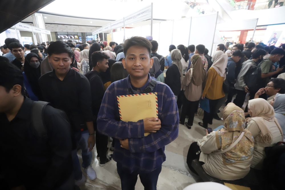 SIAP KERJA: Adam Sahertian membawa berkas lamaran kerja pada job fair di Atrium Sunrise Mall Mojokerto, kemarin (3/10).