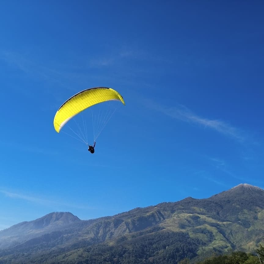 MENAWAN: Atlet paralayang melakukan uji coba terjun dari Bukit Songkro di Desa/Kecamatan Trawas, Kabupaten Mojokerto.