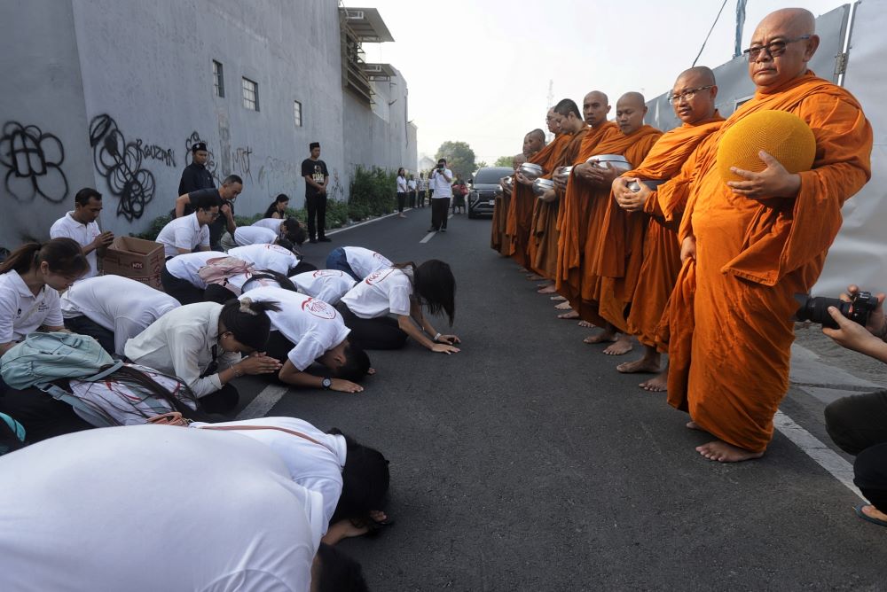 KASIH: Keluarga umat buddha berderma kepada para Biksu saat pindapatta di Magersari Kota Mojokerto, Minggu (20/10).