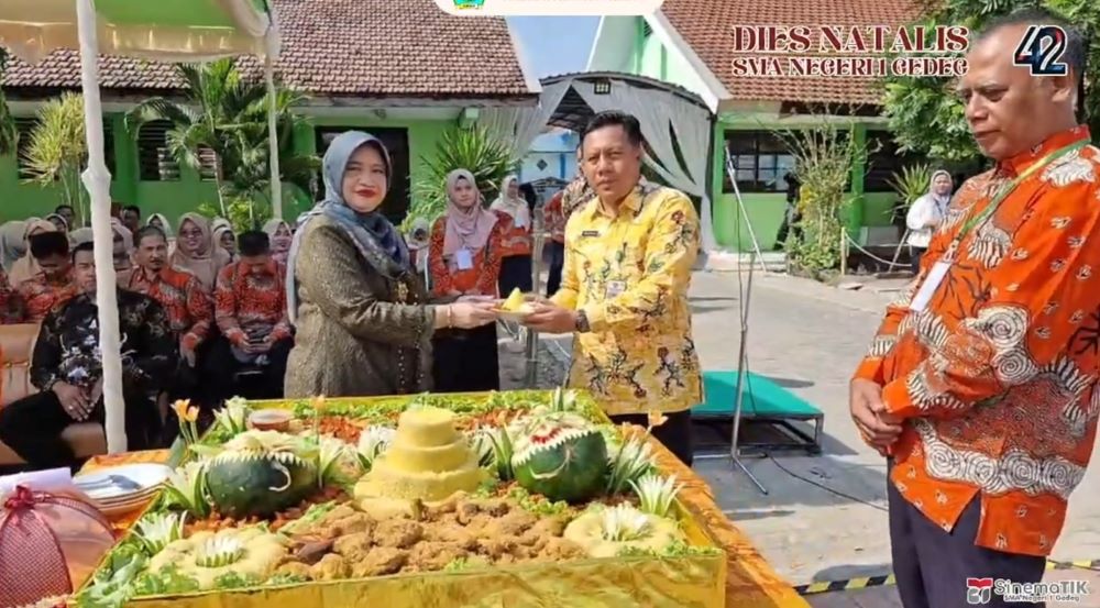 RASA SYUKUR: Kepala SMAN 1 Gedeg Nurul Wakhidah memotong tumpeng sebagai simbolis dibukanya dies natalis ke-42, Sabtu (19/10). (FT A)