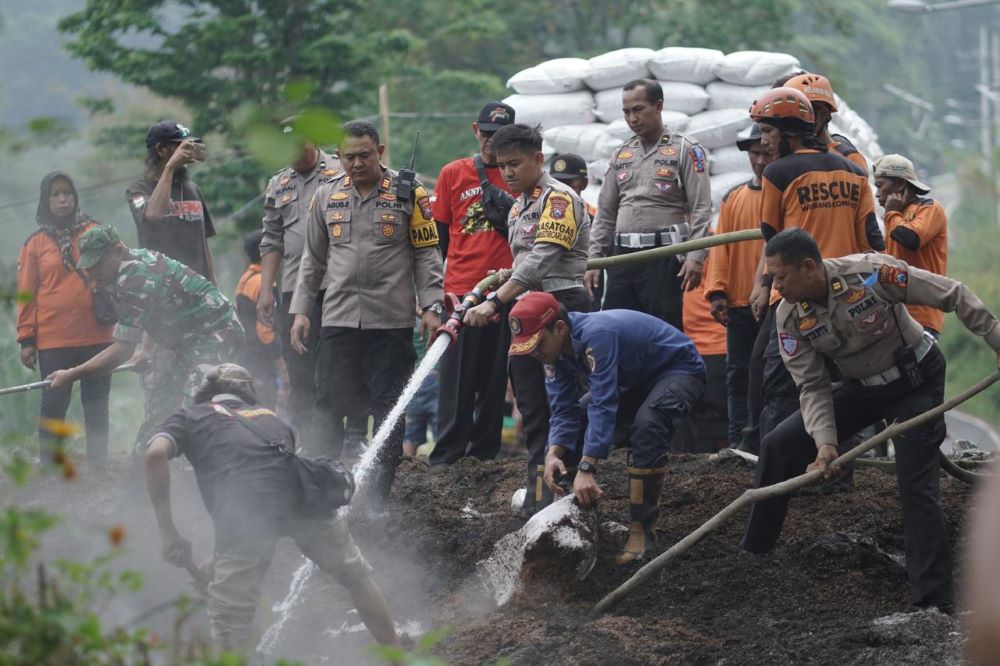 DIBANGUN ULANG: Petugas gabungan bejibaku membangun ulang benteng sekam di Jalur Penyelamat Rest Area Sendi usai dipadamkan, Selasa (22/10).