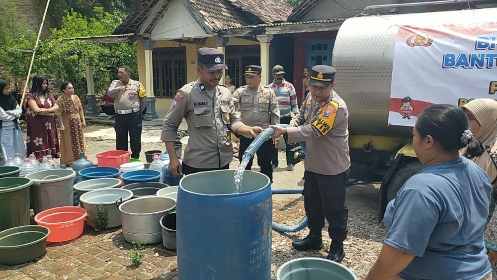 KEKERINGAN: Warga Dusun Bantengan, Desa Bendung menerima bantuan air bersih dari Polsek Jetis, Selasa (22/10).