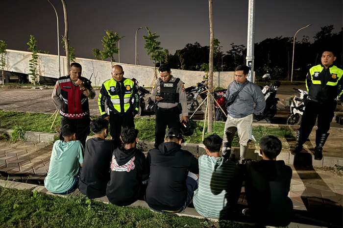 MERESAHKAN: Petugas patroli Satsamapta Polres Mojokerto Kota menginterogasi kelompok remaja beratribut gangster di TBM kawasan Rejoto, Rabu (6/11) malam.
