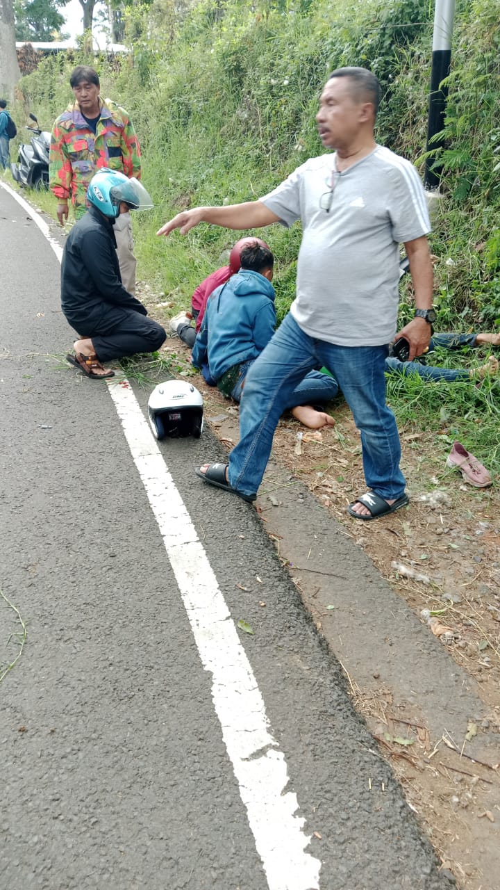 NAHAS: Korban tergeletak tak berdaya usai motor yang dikendarai mengalami rem blong dan menghantam tiang listrik di tepi jalur Pacet - Cangar, Desa/Kecamatan Pacet, Minggu (10/11).