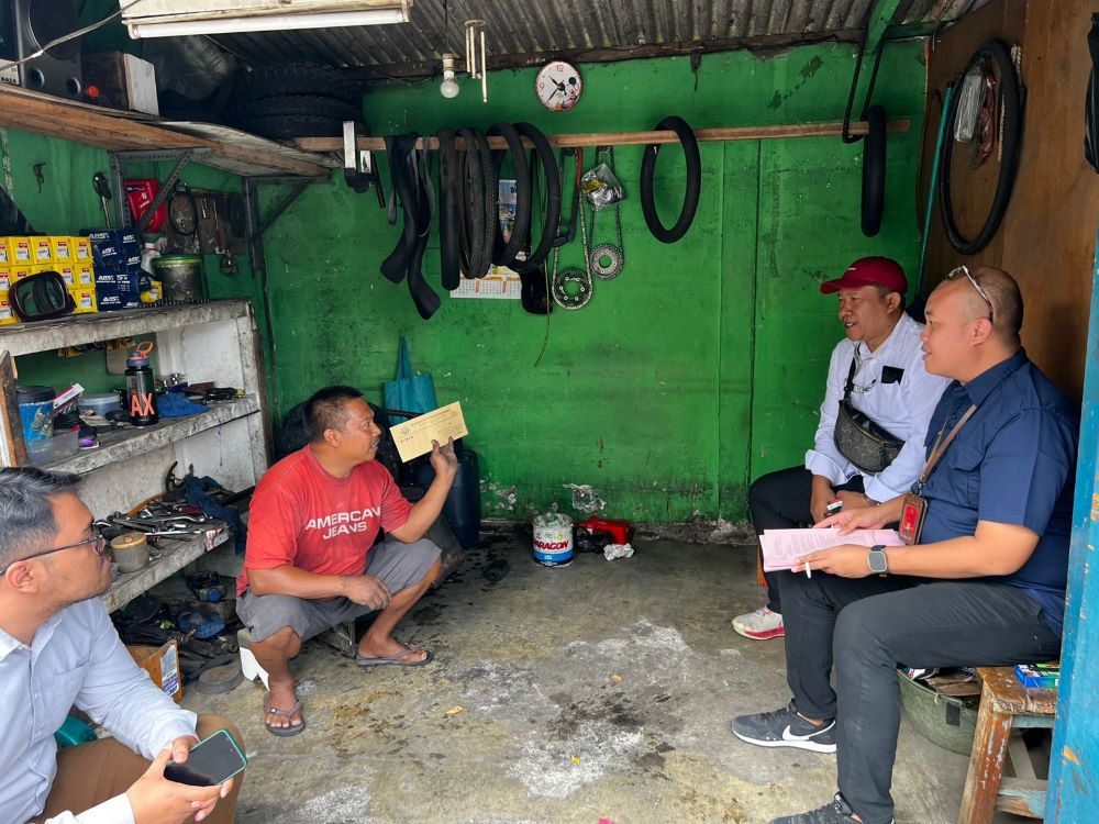 TINGGAL JEJAK: Kasi Pidsus Kejari Kabupaten Mojokerto Rizky Raditya Eka Putra (kanan) menyerahkan surat panggilan tersangka ke keluarga Noto Harianto di Malang, beberapa waktu lalu.