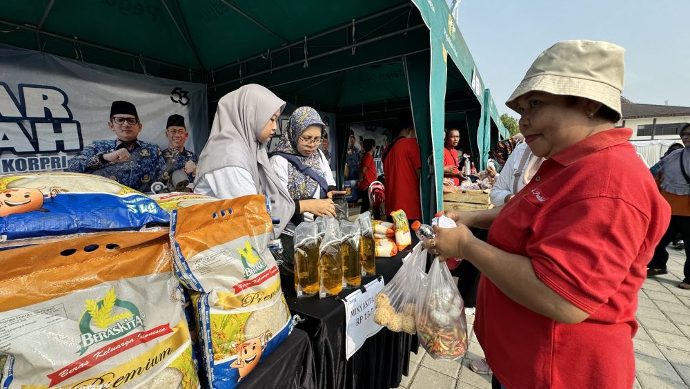 DIMINATI: Warga membeli sejumlah bahan pokok yang dijual di pasar murah di halaman parkir GOR dan Seni Mojopahit, kemarin (15/11).