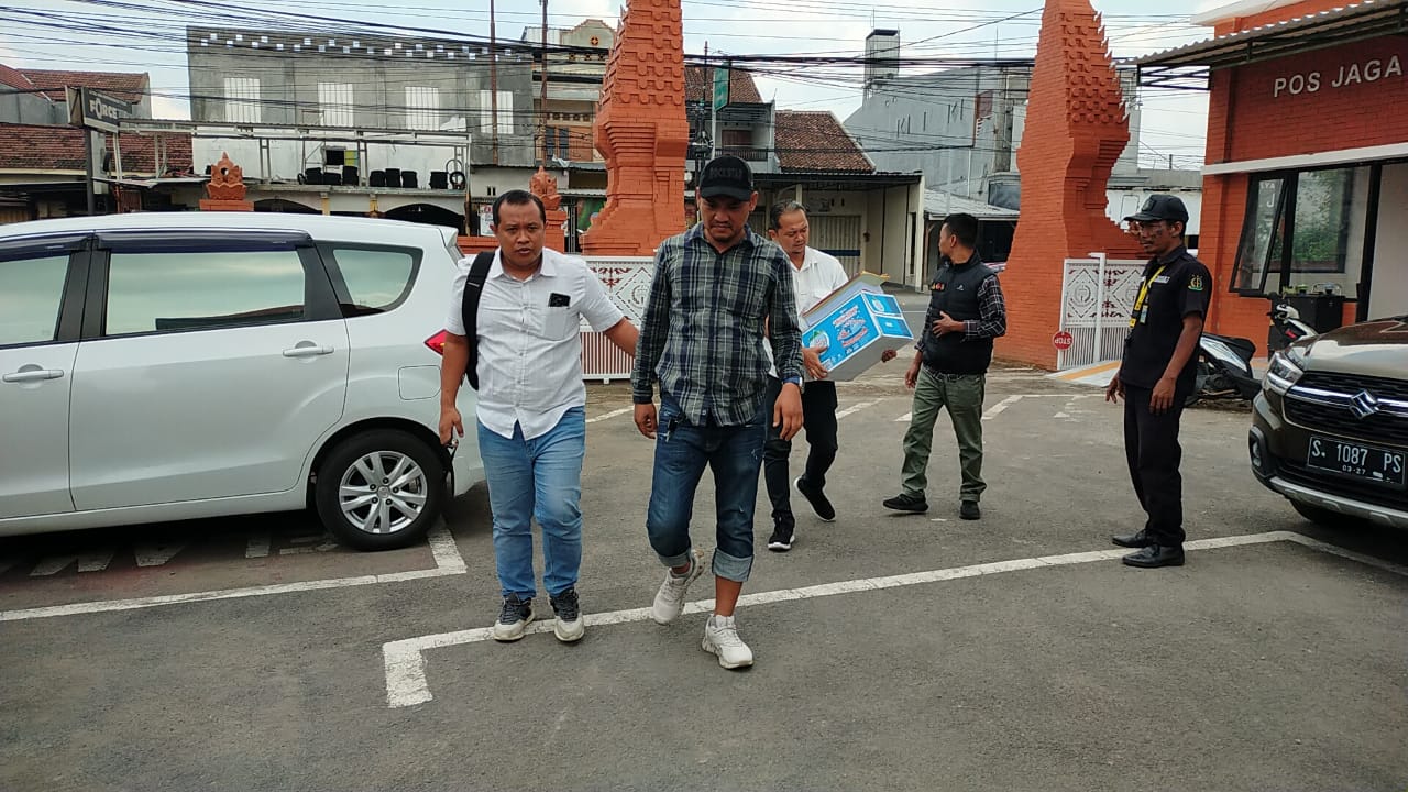 PROSES HUKUM : Kapala Desa Randuharjo, Kecamatan Pungging, Edo Yudha Arista, dikeler petugas kepolisian saat pelimpahan tahap II di kantor Kejari Kabupaten Mojokerto, Rabu (20/11).