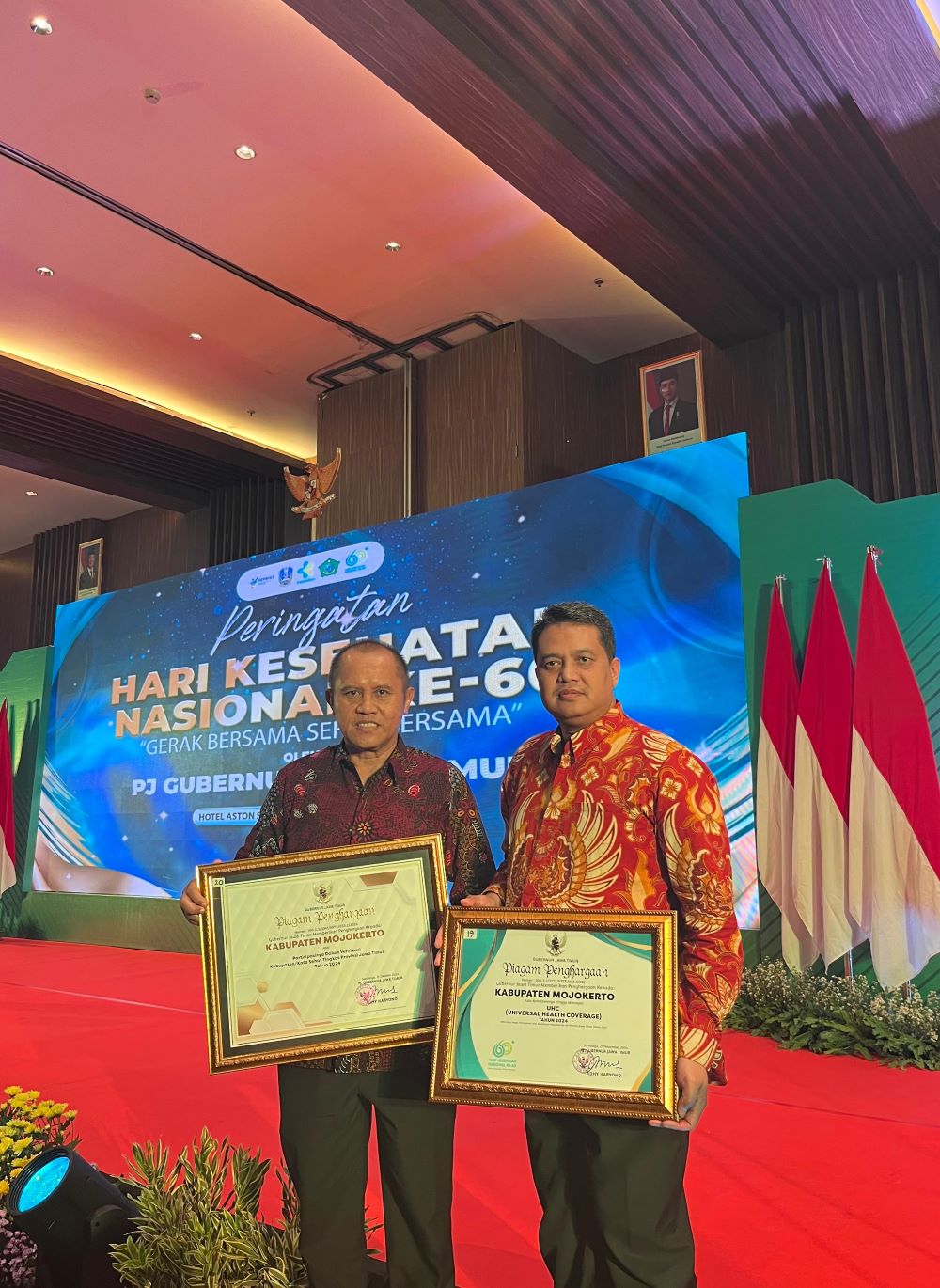 TATA KELOLA: Sekdakab Mojokerto Teguh Gunarko didampingi Kepala Dinkes Kabupaten Mojokerto dr Ulum Rokhmat Rokhmawan menerima dua penghargaan.