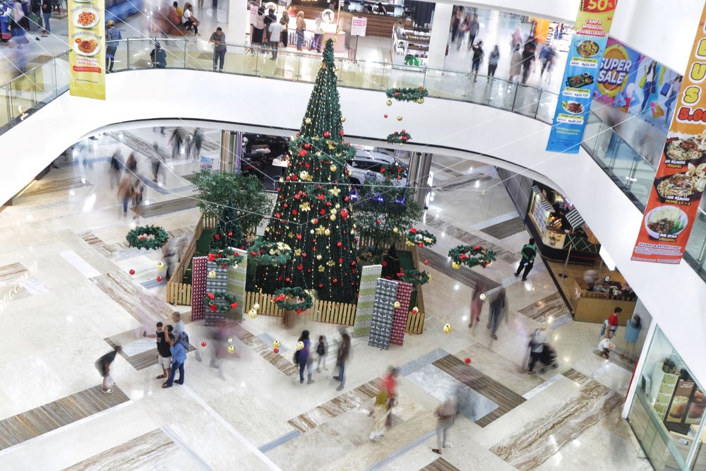 ATRAKTIF: Sejumlah pengunjung mal menggunakan pohon Natal sebagai latar belakang pengambilan foto di Sunrise Mall, kemarin.