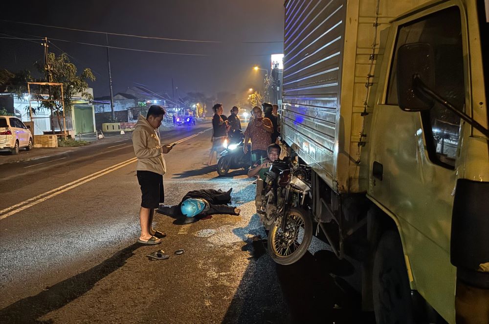 KORBAN JIWA: Korban kecelakaan, Aji Nur Yuli, tergeletak usai motor yang dikendarai menghantam truk ekspedisi di bahu Jalan RA Basuni, Desa Jampirogo, Kecamatan Sooko, Minggu (1/12) malam.