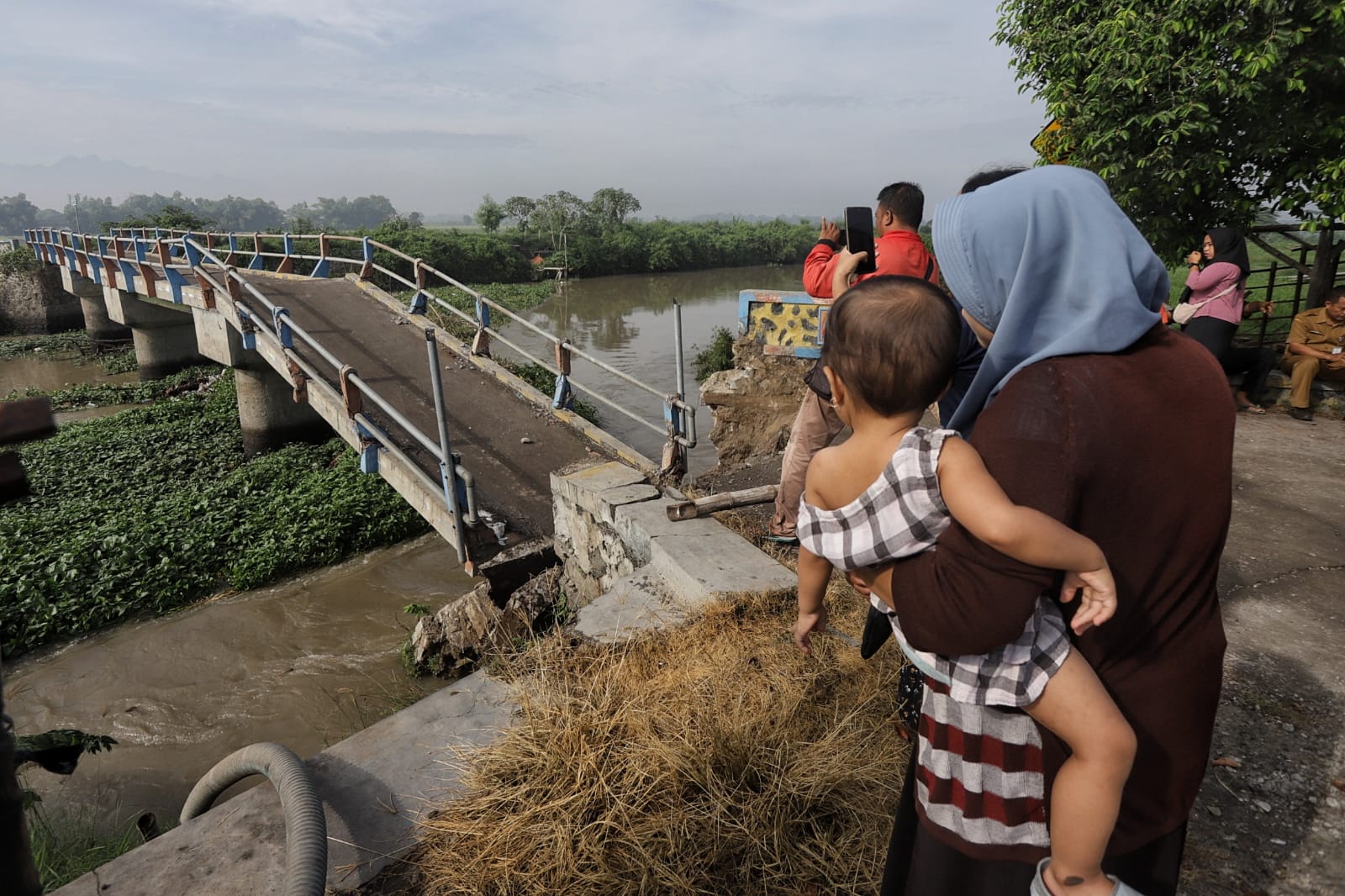 JEBOL: Warga mendatangi jembatan Desa Kedunggempol Mojosari yang jebol diterjang aliran Sungai Sadar, Selasa (3/12).