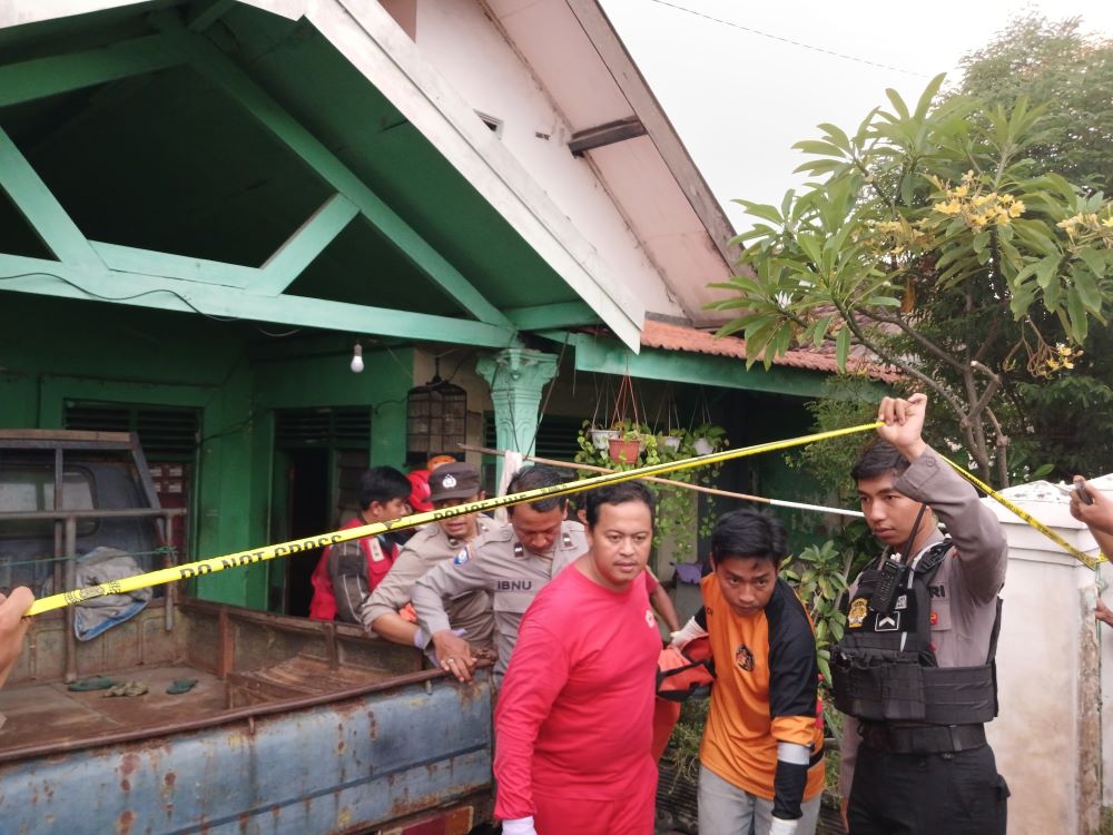 TRAGIS: Petugas mengevakuasi jasad korban tewas dalam kebakaran rumah di Miji Baru Satu Gang 1, Kota Mojokerto, kemarin.