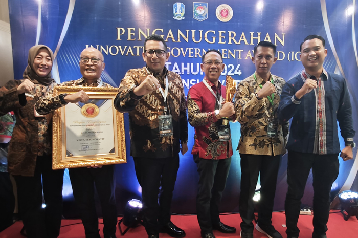 BUAH KERJA KERAS: Pj Wali Kota Mojokerto Moh. Ali Kuncoro bersama Sekdakot Gaguk Tri Prasetyo dan sejumlah pejabat lain membawa piala dan sertifikat Kota Terinovatif yang diraih pada IGA 2024.