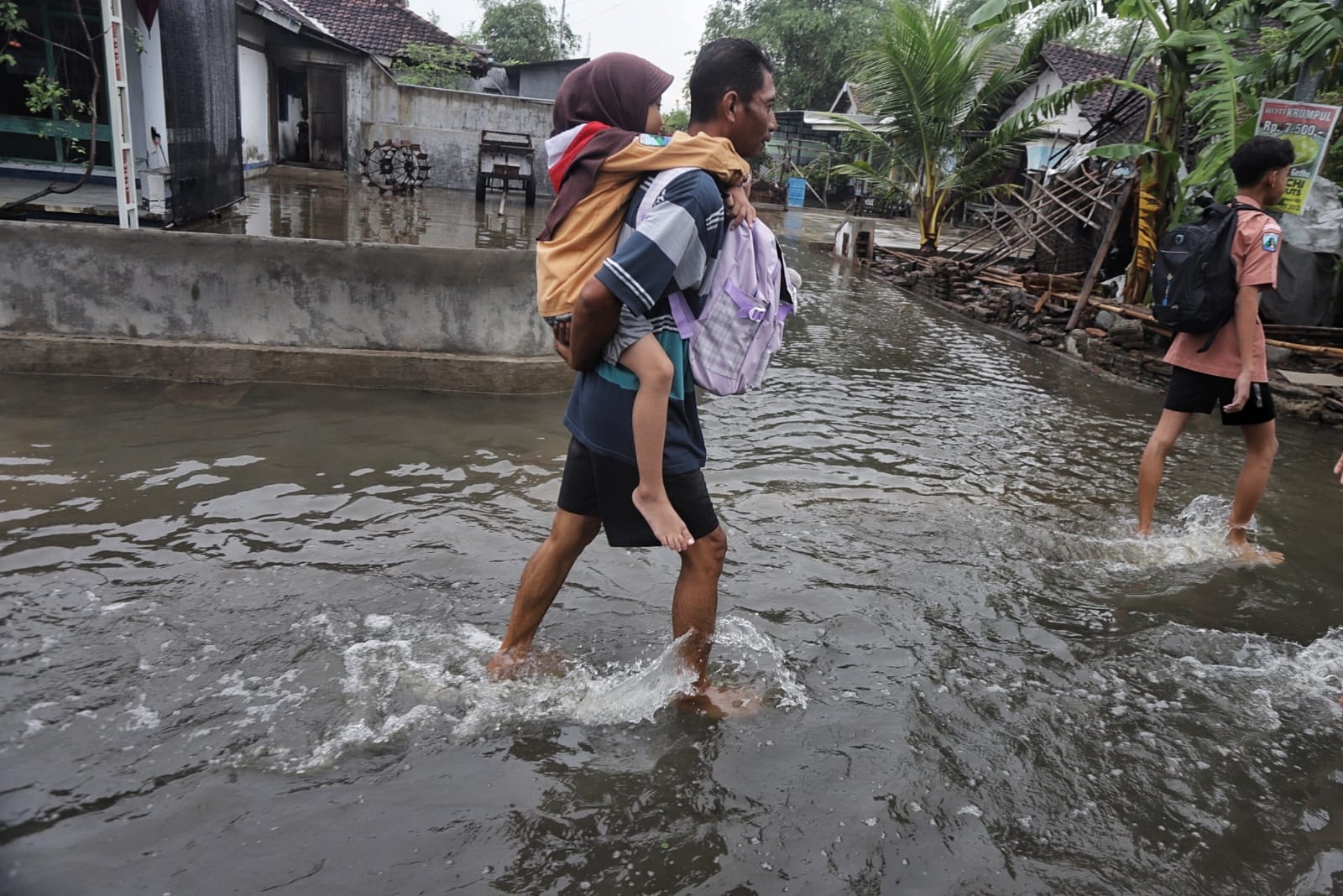 LUAPAN SUNGAI: Warga Desa Salen, Kecamatan Bangsal, Kabupaten Mojokerto beraktivitas di antara banjir akibat luapan sungai, Jumat (6/12) pagi.
