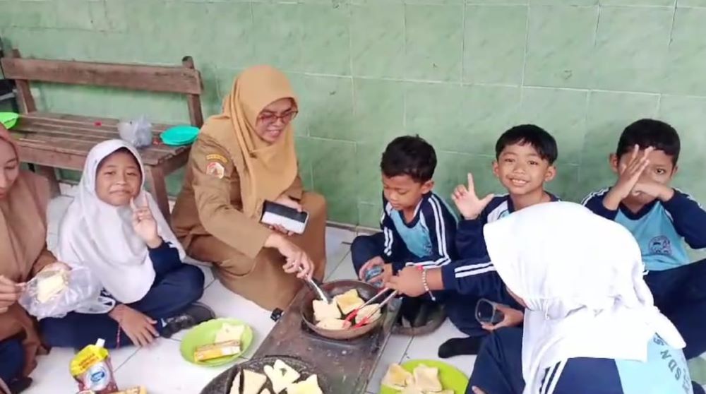 ASAH KETERAMPILAN: Kepala SDN Segunung Alifah Nanik Hidayatin mendampingi siswa saat menggelar cooking class, kemarin (9/12).