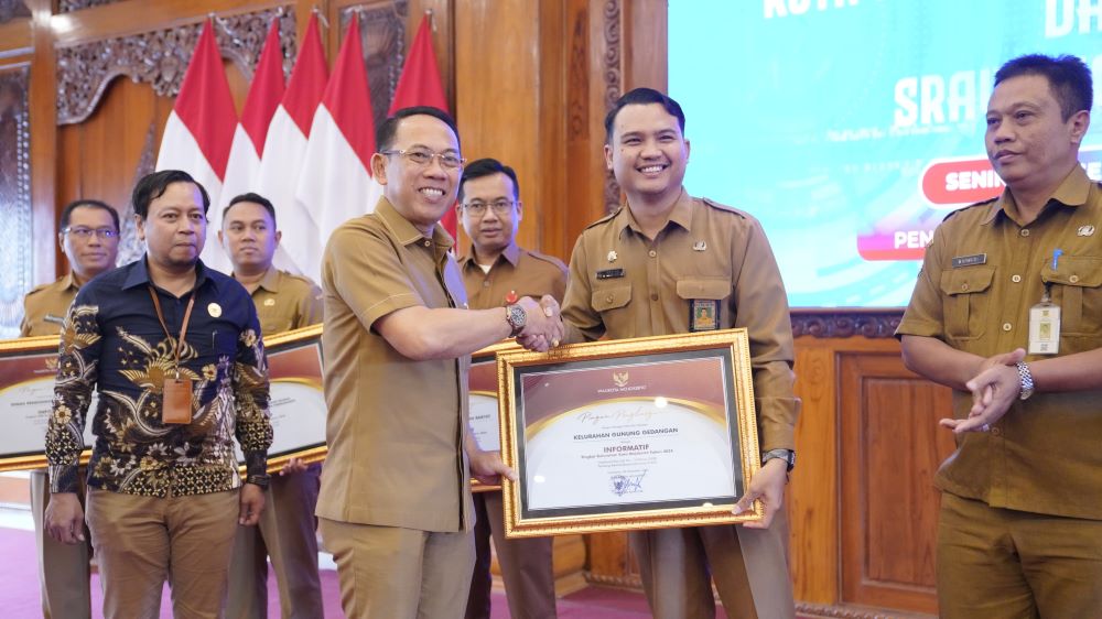 APRESIASI: Sekretaris Daerah Kota Mojokerto Gaguk Tri Prasetyo memberikan piagam penghargaan Kelurahan Terinformatif kepada Lurah Gunung Gedangan Andika Dewantara di Pendapa Sabha Mandala Madya.
