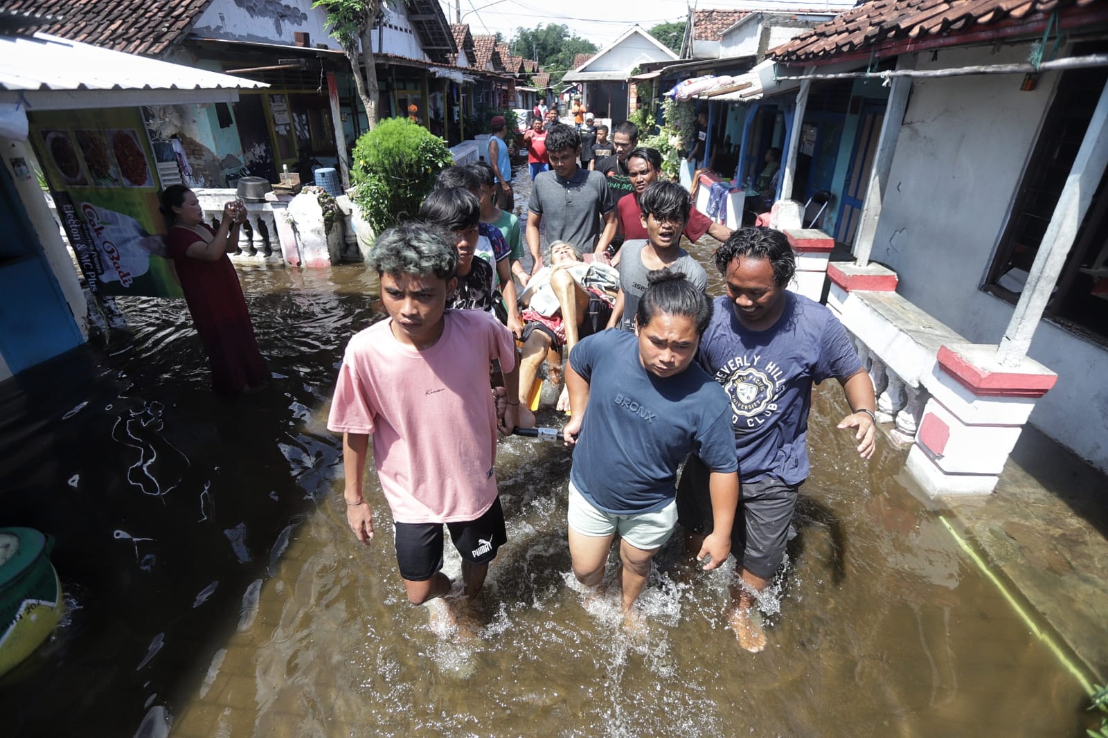 DIEVAKUASI: Sejumlah warga mengevakuasj lansia sakit yang terjebak banjir di Lingkungan Cakarayam Baru, Kelurahan Mentikan, Kecamatan Prajurit Kulon, Kota Mojokerto, Selasa (10/12).&nbsp;