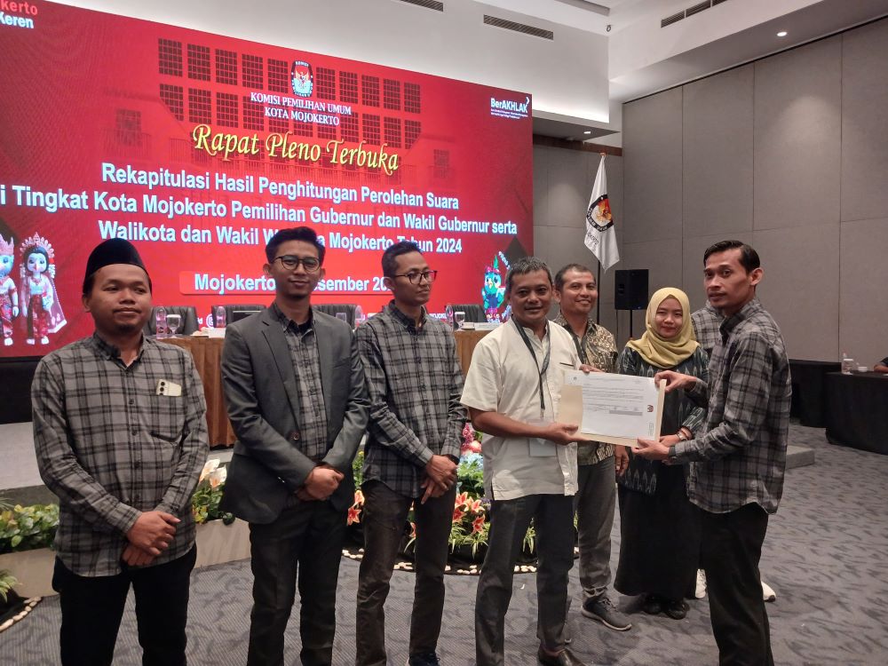HASIL AKHIR: Ketua KPU Kota Mojokerto Usmuni menyerahkan berita acara rekapitulasi tingkat kota kepada saksi paslon pilwali, Minggu (1/12).
