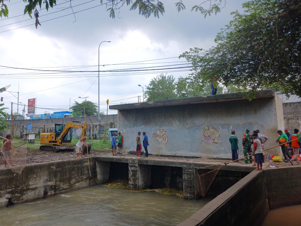 PEMICU UTAMA: Proses pembersihan sampah di bak kontrol dam sipon utara di Desa Pagerluyung, Kecamatan Gedeg, kemarin (13/12).