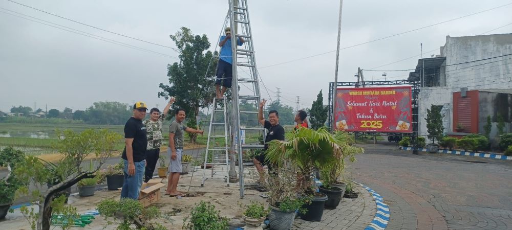 CIAMIK: Warga gotong royong memasang kerangka pohon natal yang dihiasi lampu wara warni di gerbang masuk Perumahan Mutiara Garden, Sabtu (14/12) lalu.