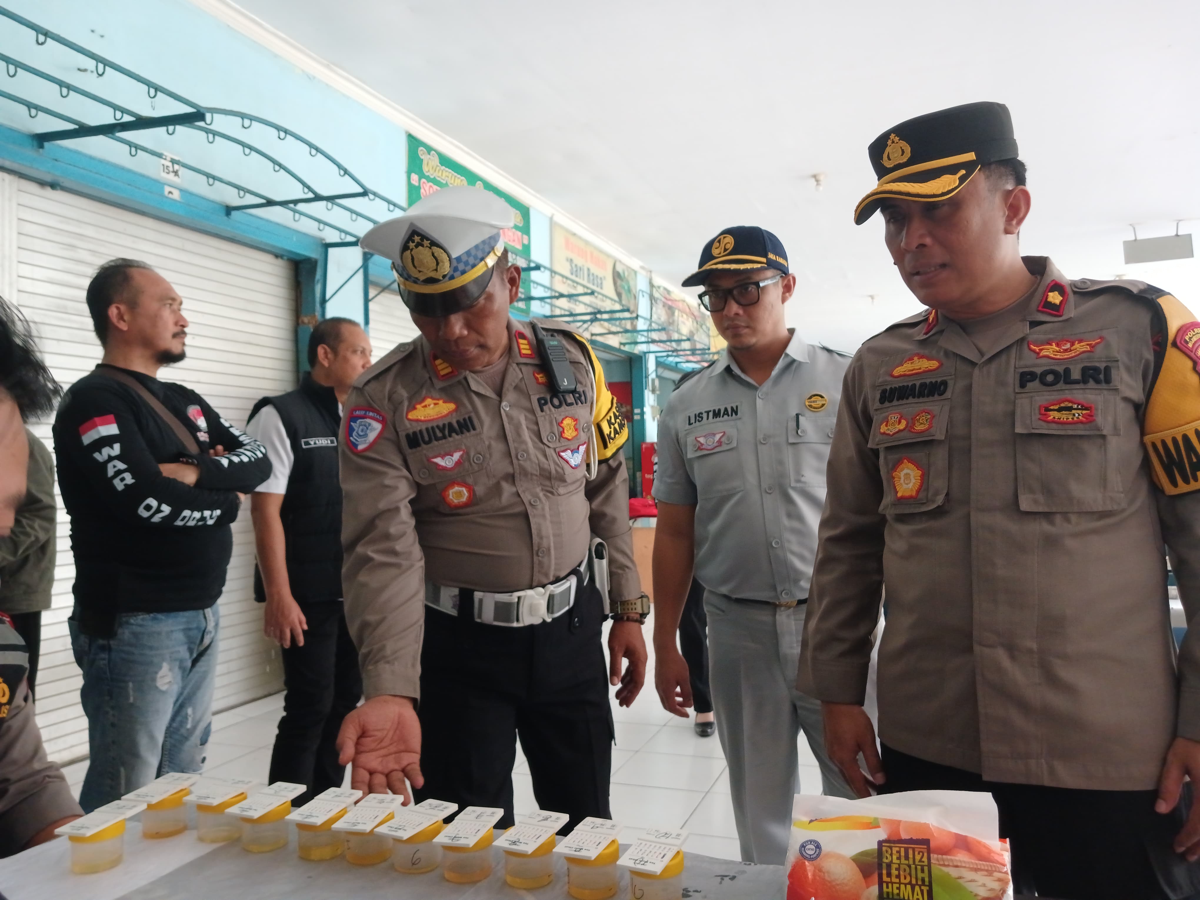 CEGAH LAKA LANTAS: Wakapolres Mojokerto Kota Kompol Suwarno dan Kasatlantas AKP Mulyani memeriksa hasil tes urine sopir bus di Terminal Kertajaya, Selasa (24/12).