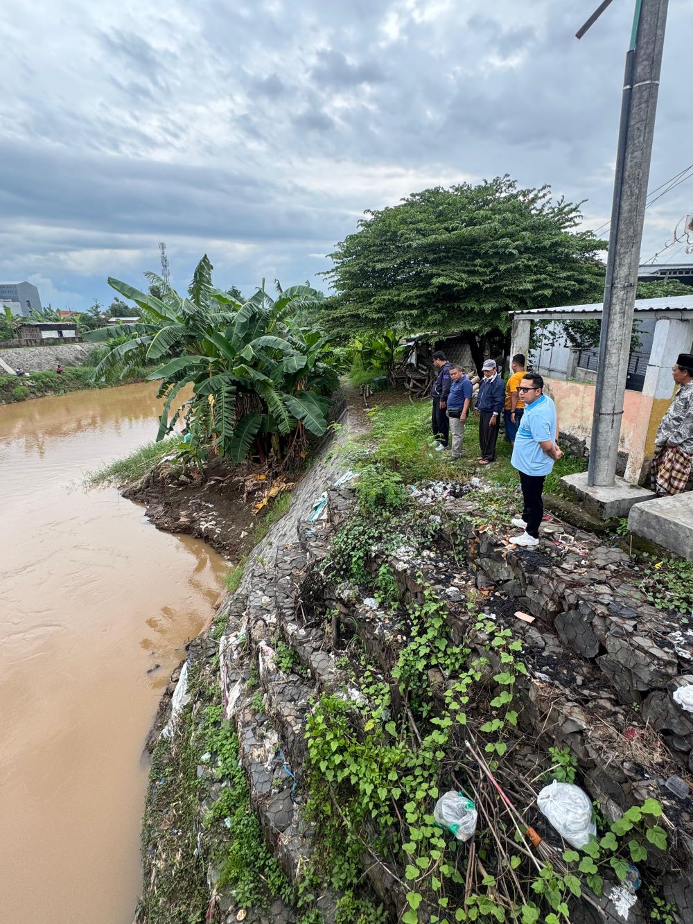 DITINJAU: Penjabat Wali Kota Mojokerto Moh. Ali Kuncoro didampingi Camat Prajurit Kulon Riaji saat meninjau titik tanggul yang ambrol di aliran Sungai Brangkal, Kamis (26/12).