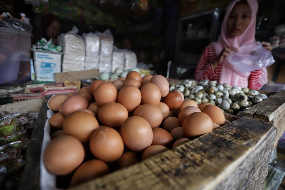 NAIK: Pedagang telur ayam ras di Pasar Tanjung Anyar, Kota Mojokerto, sedang melayani pembeli, kemarin (29/12).