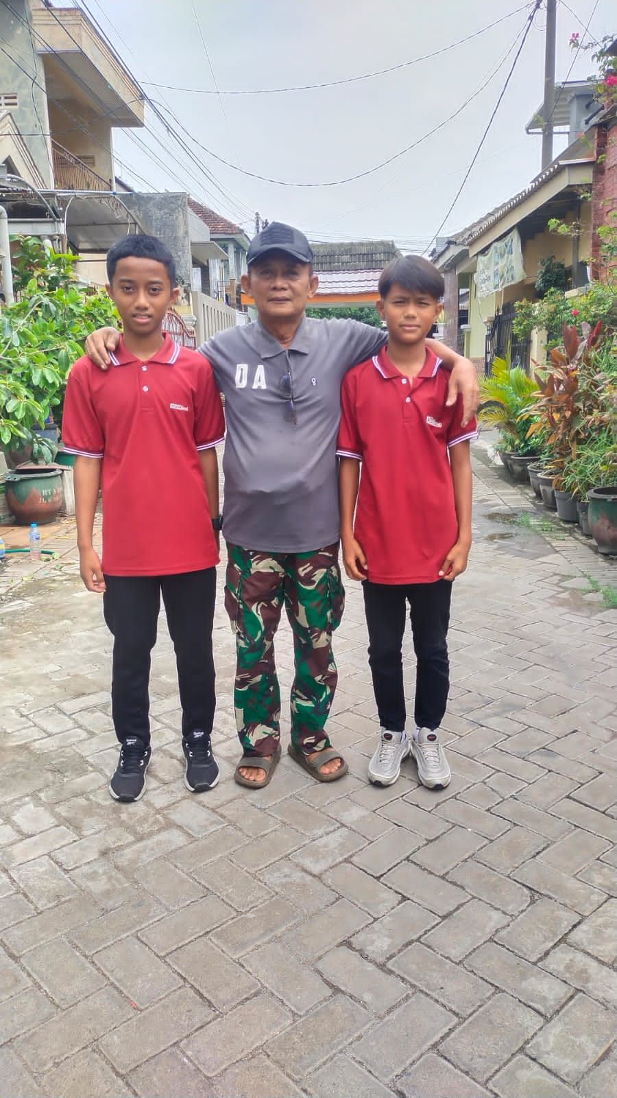 KEBANGGAAN: Dua siswa sekaligus anggota SSB SISOO FA Mojokerto bersama sang pelatih bersiap menuju turnamen sepak bola pelajar se-Asia, pertengahan Januari nanti.