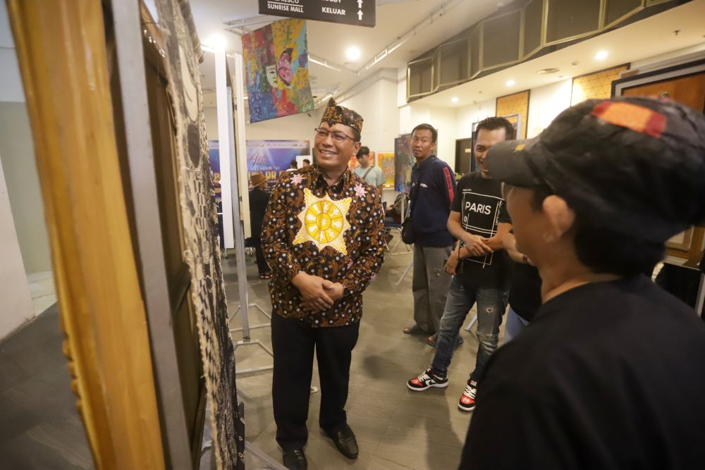 BERTALENTA:&nbsp; Kepala Dikbud Kota Mojokerto Ruby Hartoyo menilik lukisan karya Erlangga Prajna Rajendra dan Tiffany Calisya Allegra di pameran SAL #10, Minggu (5/1).
