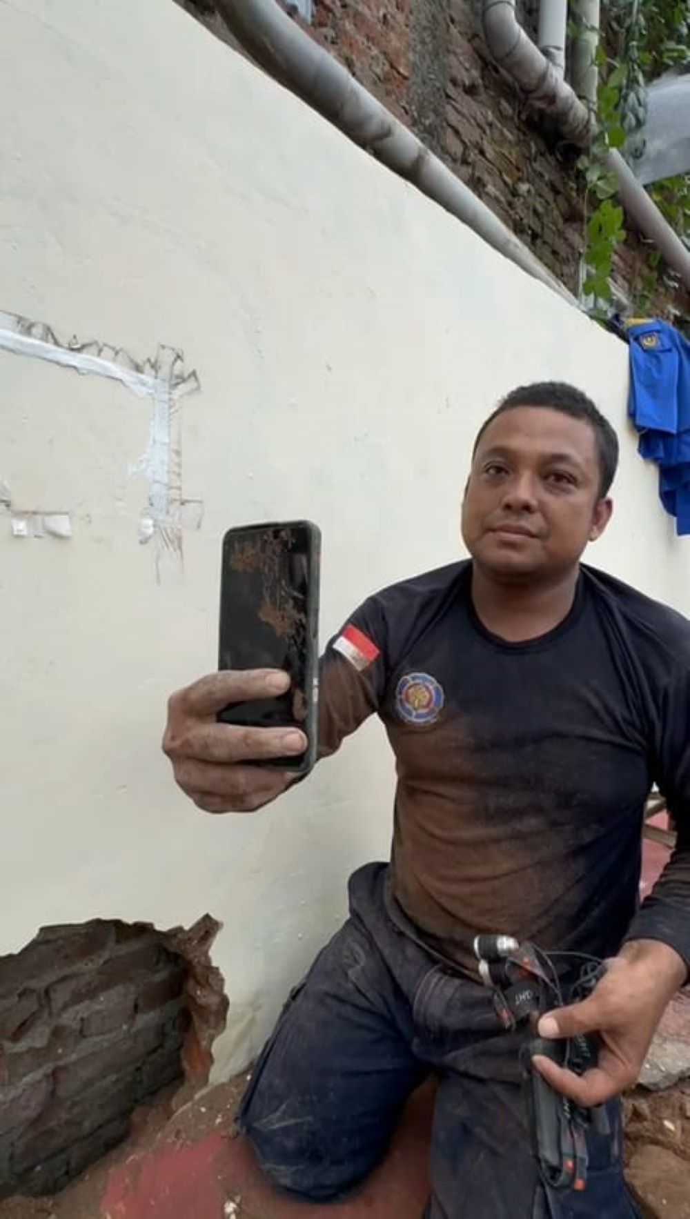 BUTUH DUA JAM: Petugas Damkar Kota Mojokerto saat membantu mengambil HP milik warga dari sela tembok di Stadion Ahmad Yani, kemarin (8/1).