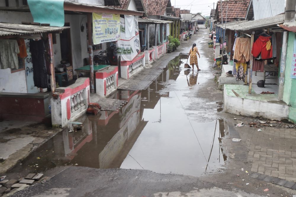DIBEBASKAN: Warga Lingkungan Balongcangkring 2, Kelurahan Pulorejo, Kecamatan Prajurit Kulon membersihkan sisa banjir akhir tahun lalu.
