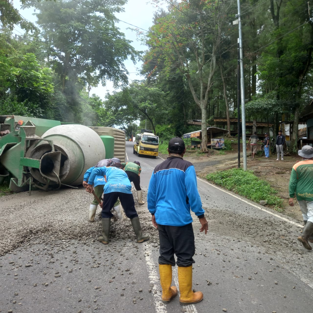 MELINTANG: Truk molen Nopol S 8653 UN terguling akibat rem blong saat gagal nanjak di Jalan Raya Jatijejer, Kecamatan Trawas, Senin (13/1) siang.
