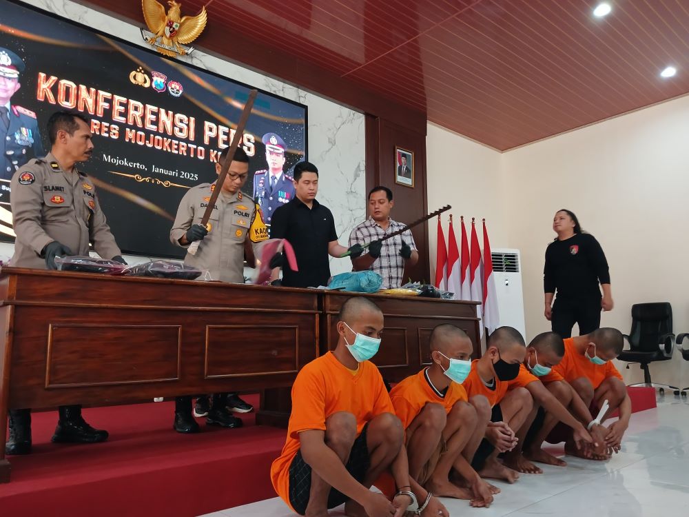 MASIH BERGULIR: Polisi menunjukkan tersangka dan barang bukti pedang saat jumpa pers, Kamis (16/1).