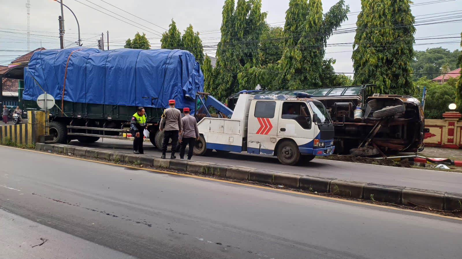 KECELAKAAN TUNGGAL: Truk gandeng muatan bahan pakan ternak terguling usai menghantam median jalan di depan SPN Bangsal, Selasa (21/1) pagi.