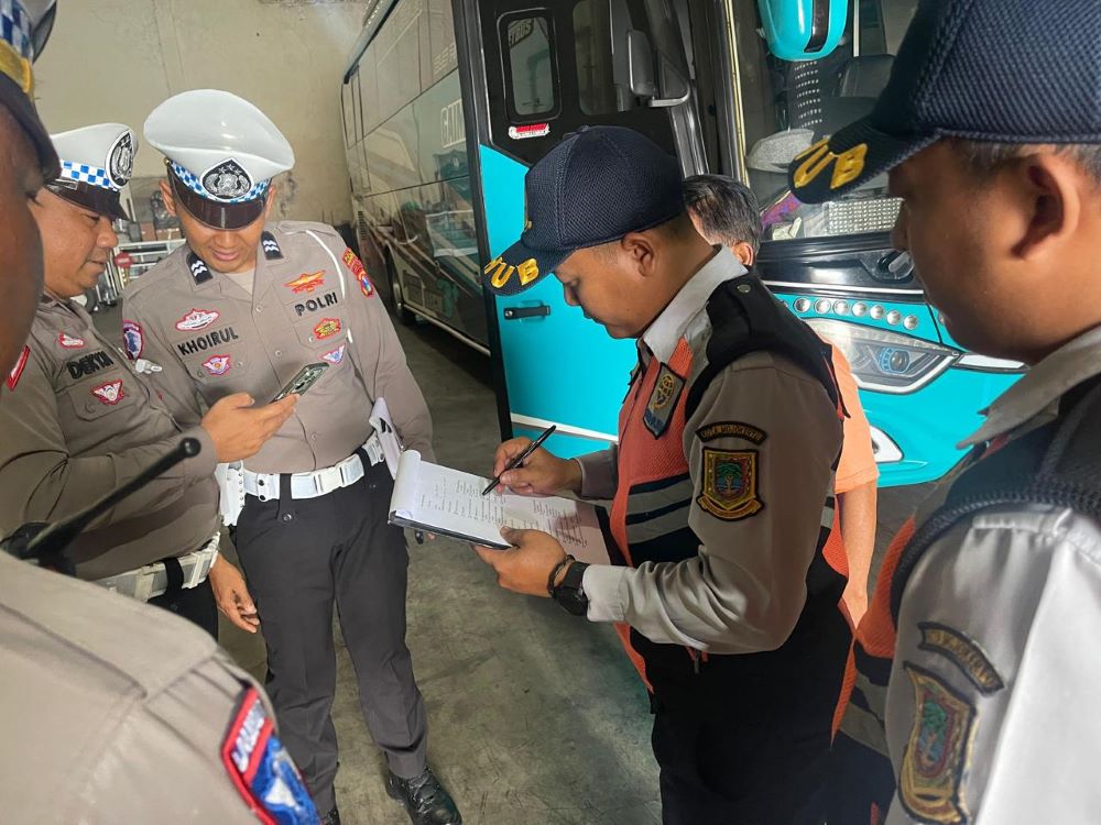 DIPERIKSA: Anggota Satlantas Polres Mojokerto Kota dan dishub memeriksa kondisi bus pariwisata di garasi, kemarin.