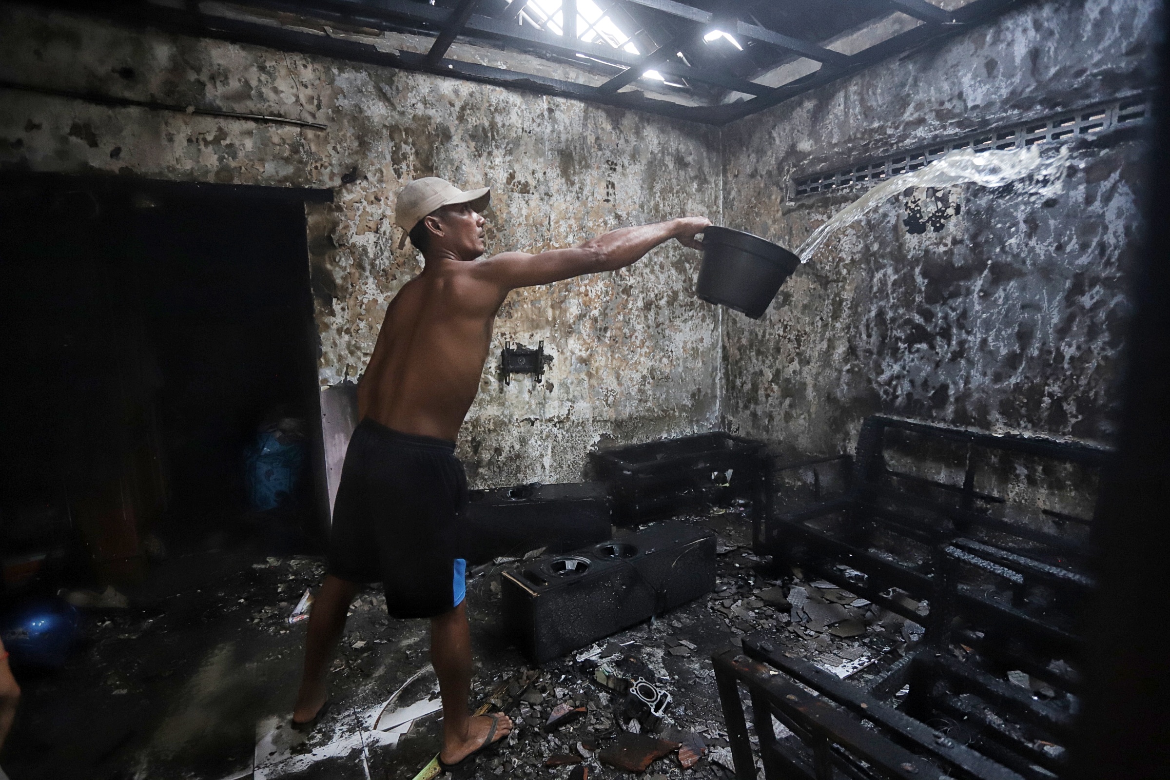 HANGUS: Warga melakukan pembasahan setelah pemadaman kebakaran rumah di Dusun Kemantren Wetan, Desa Terusan, Kecamatan Gedeg, Kabupaten Mojokerto, Jumat (24/1).