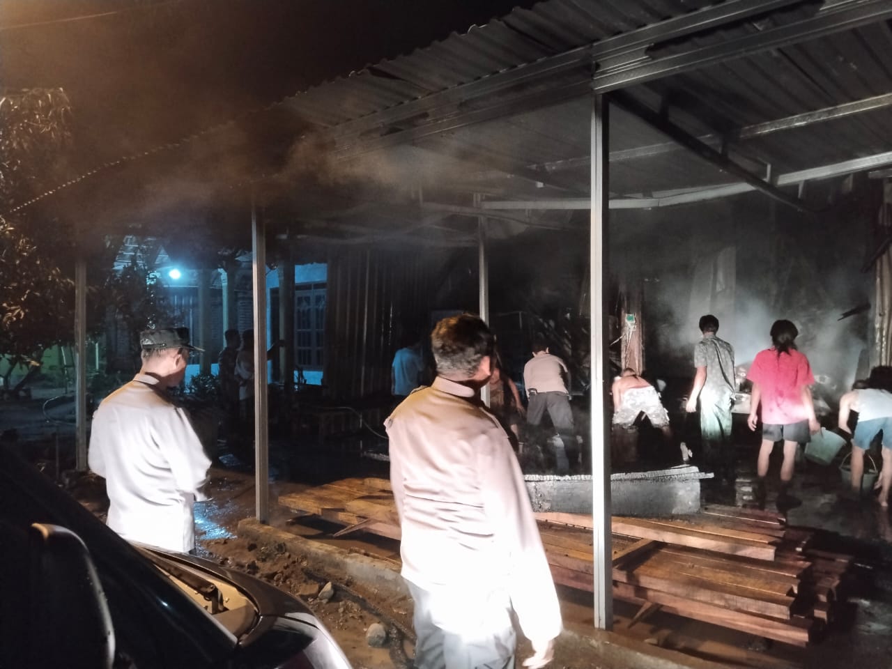 LUDES: Petugas bersama warga memastikan api yang meludeskan gudang helm di Desa Jambuwok, Kecmatan Trowulan, sudah tidak membara, Rabu (29/1).