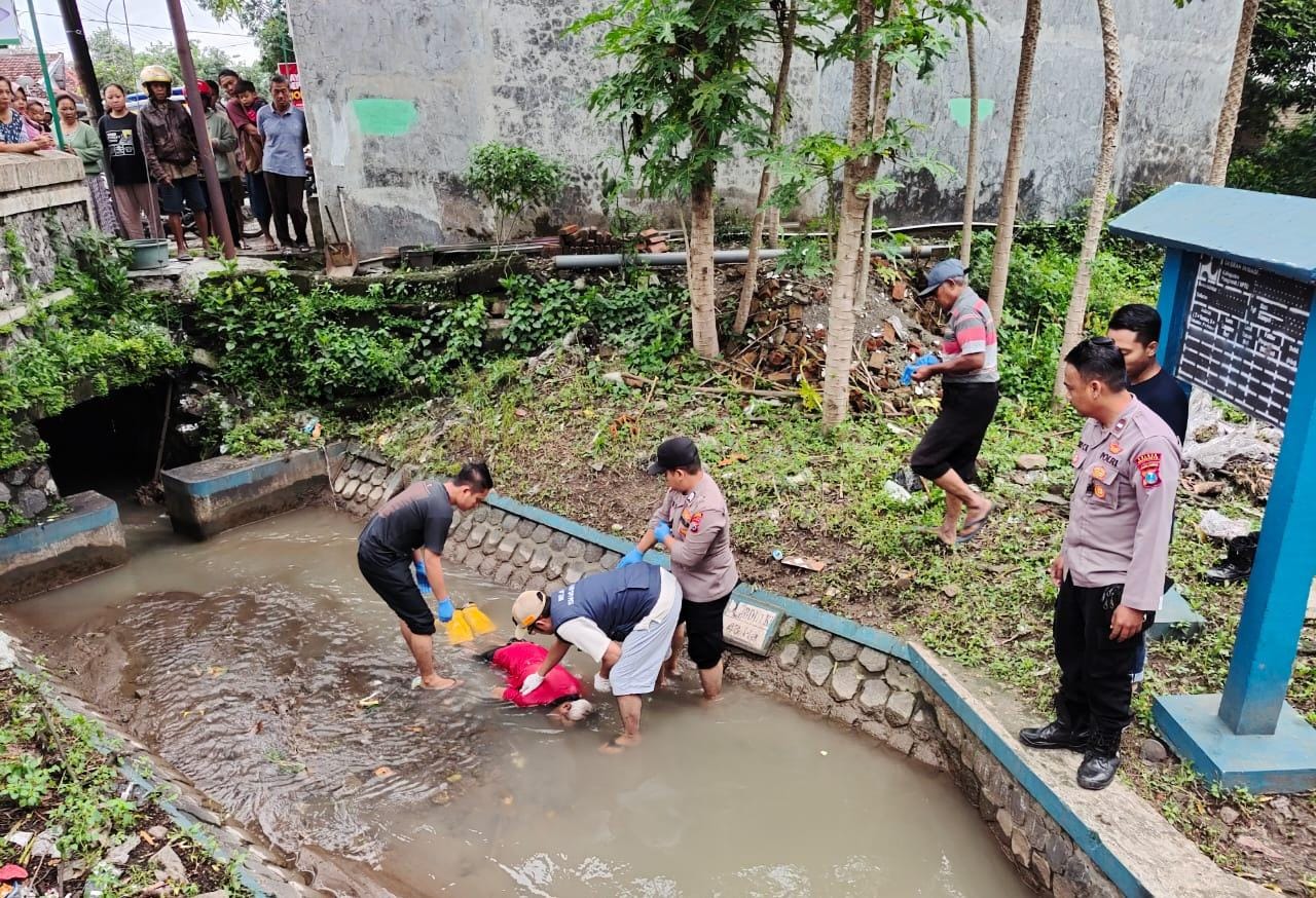 BIKIN GEGER: Petugas Polsek Dlanggu mengevakuasi jasad korban yang nyungsep di aliran sungai, Kamis (30/1).