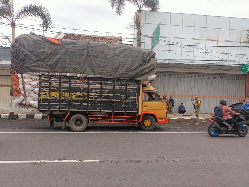 DOBEL PELANGGARAN: Petugas Satpol PP Kota Mojokerto menghentikan truk ODOL yang menabrak kabel listrik hingga terputus di Jalan Mojopahit, kemarin.